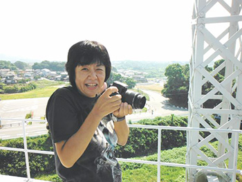 三池炭鉱宮原坑跡でカメラを構える熊谷さんの写真